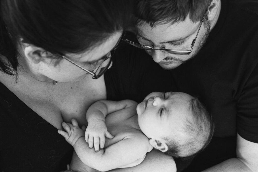Newborn baby being held by loving parents in Woking