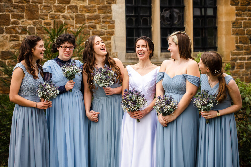 bridesmaids laughing outside church wedding