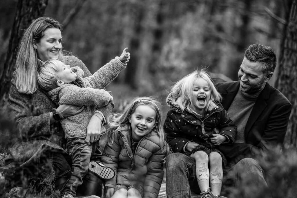 family laughing in the woods in Farnham