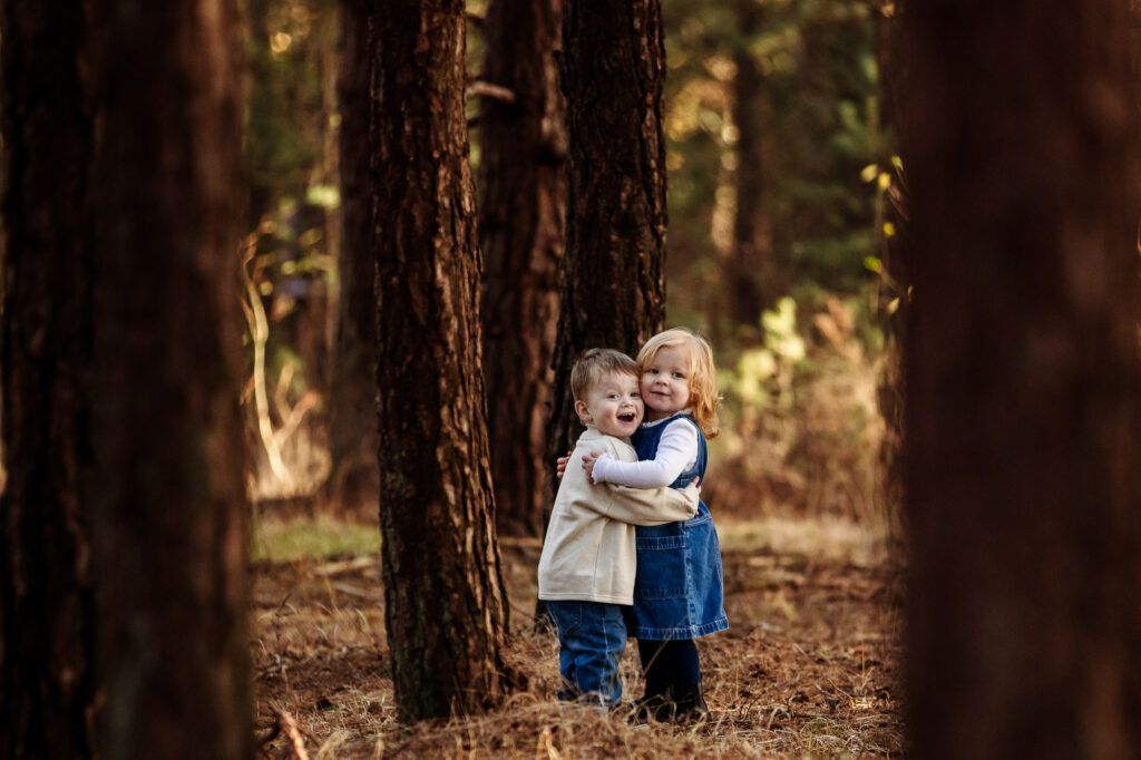 children hugging in the woods in Godalming